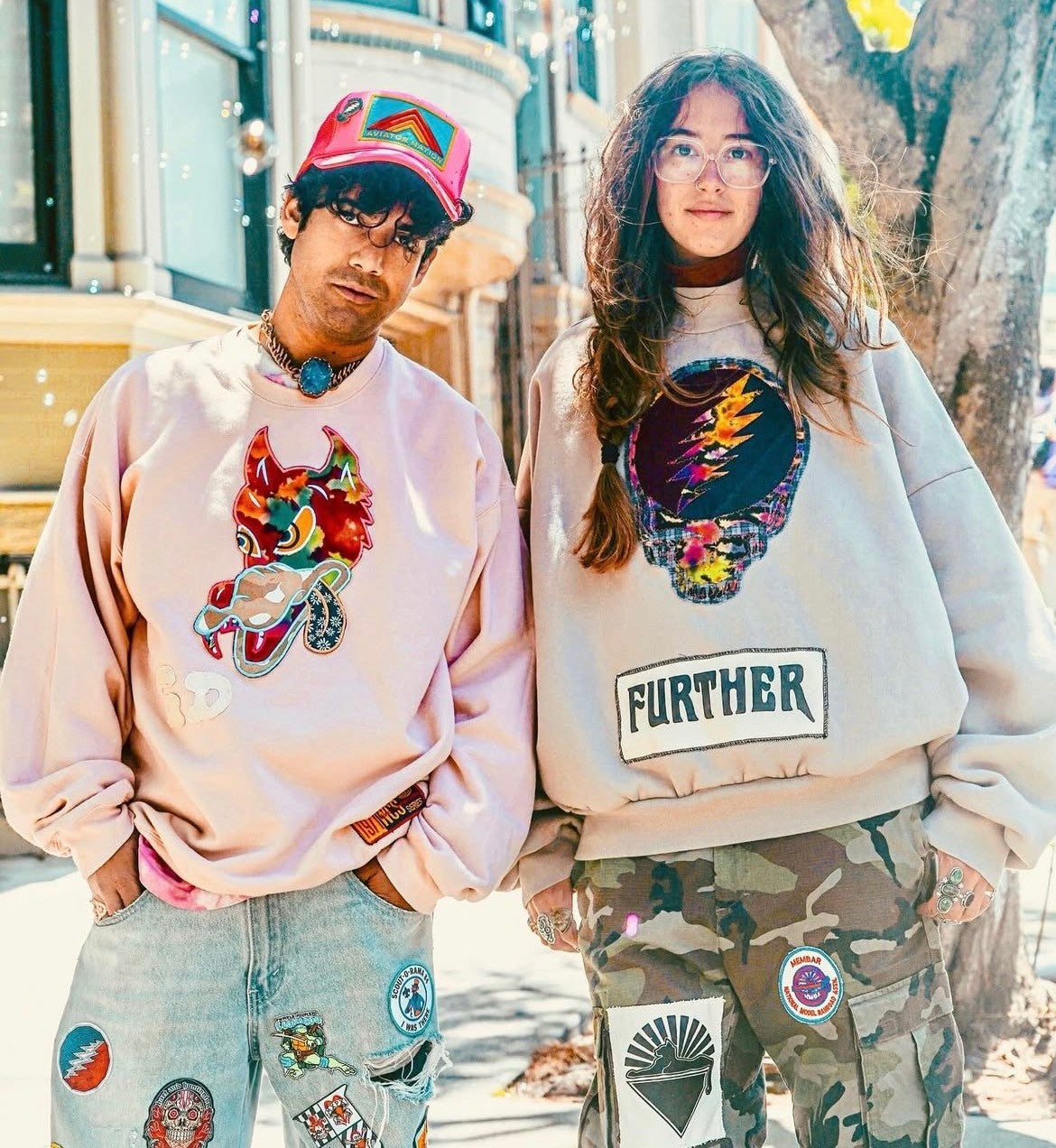 Close-up of couple in Further sweatshirts with devil cat graphic and Stealie skull patch