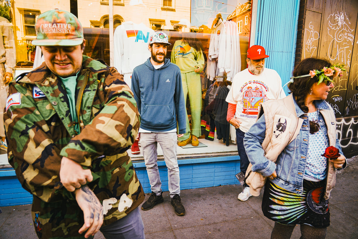 Friends gathered outside a Haight Street shop front with Further clothing on display